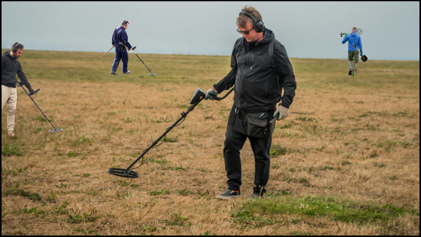 Vernetzt euch mit anderen Sondlern: Eine Gruppe von Sondengängern bei der gemeinsamen Suche mit Metalldetektoren auf einer Wiese.