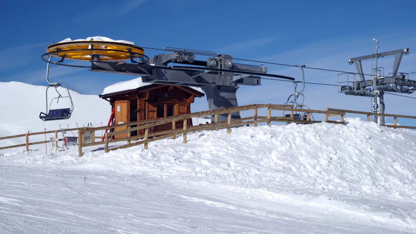 Skiliftstation mit Holzgebäude, Seilrollen und Sessellift auf einem verschneiten Berg bei klarem Winterwetter – typisches Suchgebiet, in dem im Winter oft moderne Kleinfunde verloren gehen.