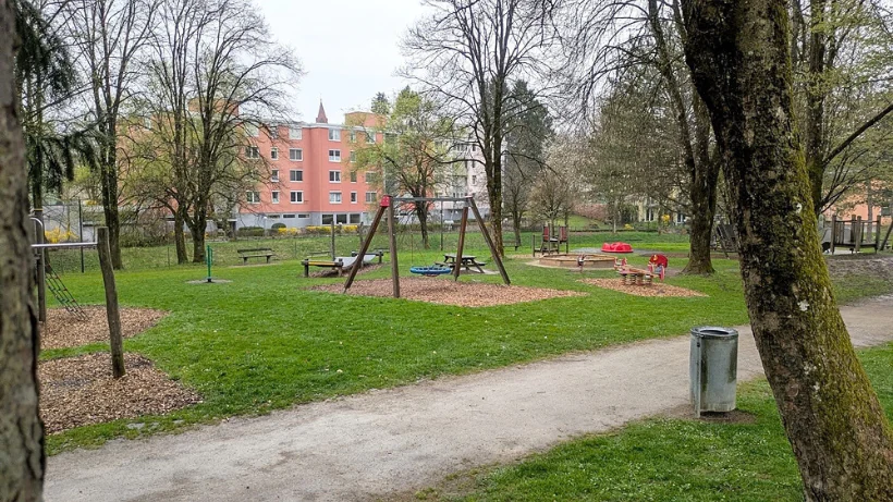 Moderner Spielplatz in einem Stadtpark mit Schaukeln, Klettergeräten und Holzschnitzelboden – ein typisches neuzeitliches Suchgebiet mit vielen möglichen Kleinfunden.