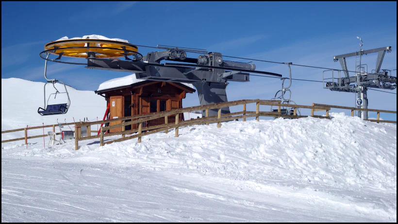 Skiliftstation mit Holzgebäude, Seilrollen und Sessellift auf einem verschneiten Berg bei klarem Winterwetter – typisches Suchgebiet, in dem im Winter oft moderne Kleinfunde verloren gehen.