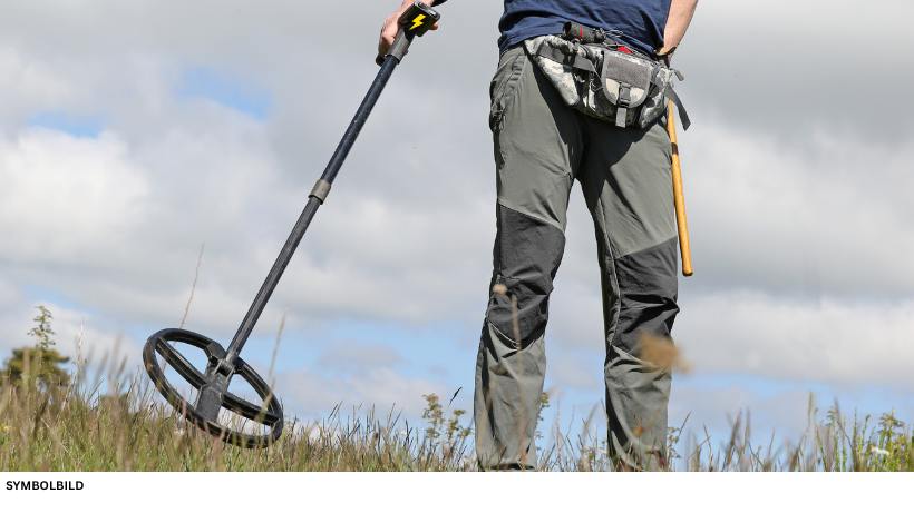 Metalldetektor für Anfänger – Person hält den Detektor ergonomisch im Einsatz, Batteriefach markiert
