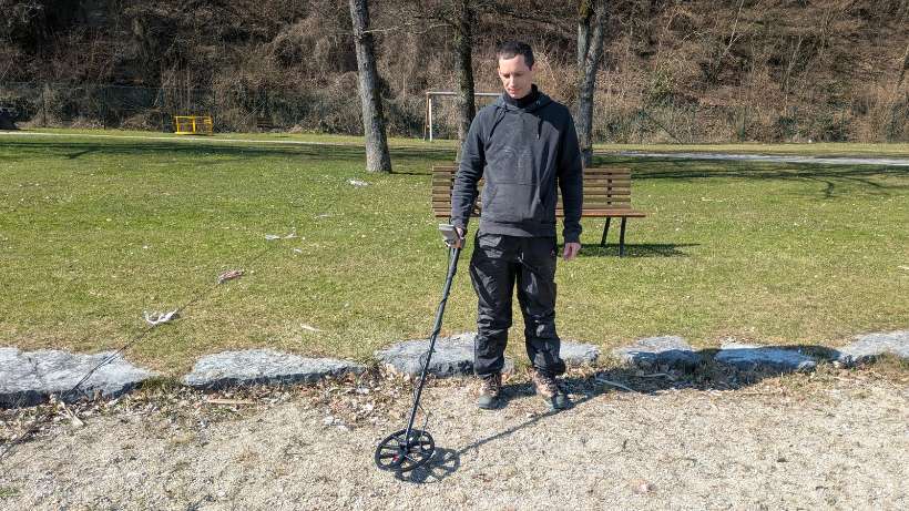 Minelab X-Terra Elite im Praxiseinsatz: Ich schwenke den Metalldetektor auf einem Kiesweg bereit für den ersten Suchgang.