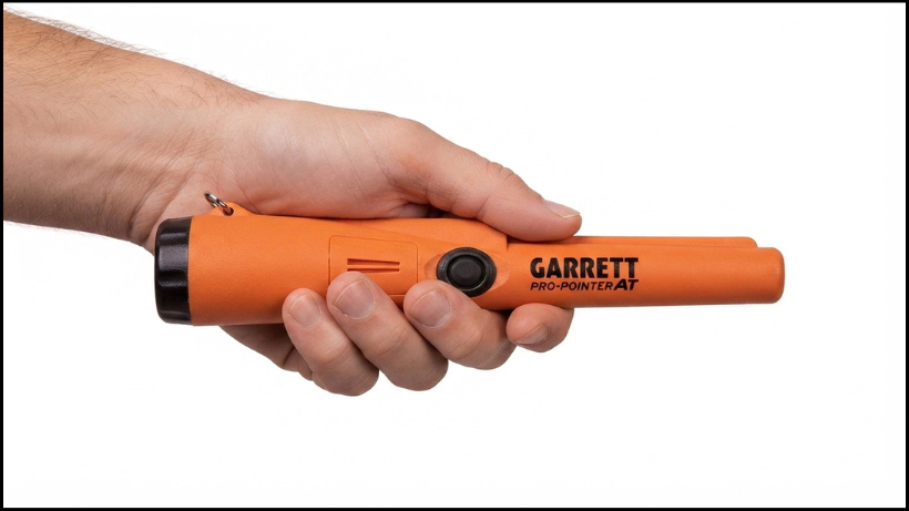 Hand hält den Garrett Pro‑Pointer AT, gut sichtbare Ein‑Knopf‑Bedienung und ergonomische Form für sicheren Halt und präzise Führung.