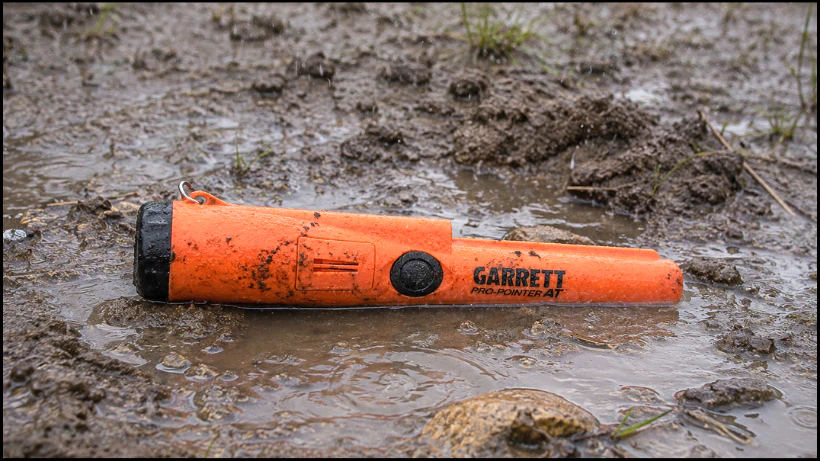 Wasserdichter Pinpointer (IP68) liegt im nassen, schlammigen Boden und zeigt robuste Outdoor‑Tauglichkeit bei feuchten Bedingungen.